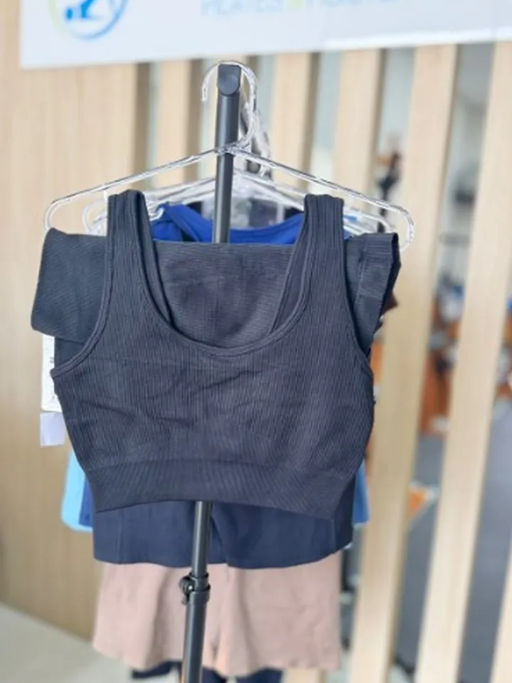 Conjunto preto canelado, short e top, pendurado na arara da recepção do estúdio